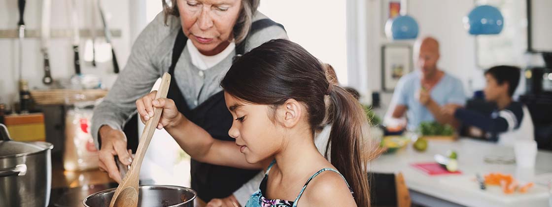 Abuela da indicaciones a la nieta para preparar una receta y compartir en familia