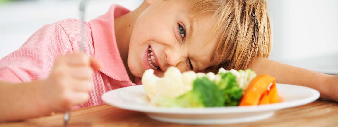 Niño toma una cena ligera que incluye verduras para dormir bien y sin pesadez