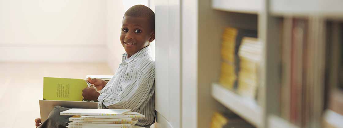 Niño visita la biblioteca para elegir un título que le guste para leer